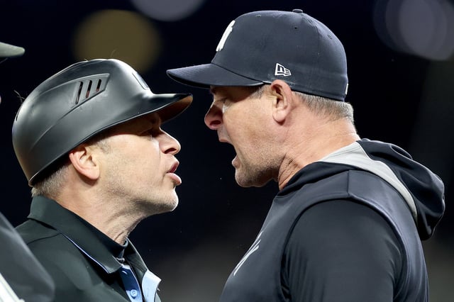 SEATTLE, WASHINGTON - MAY 13: Umpire Mark Wegner #14 and manager Aaron Boone #17 of the New York Yankees yell at each other during the ninth inning at T-Mobile Park on May 13, 2025 in Seattle, Washington.