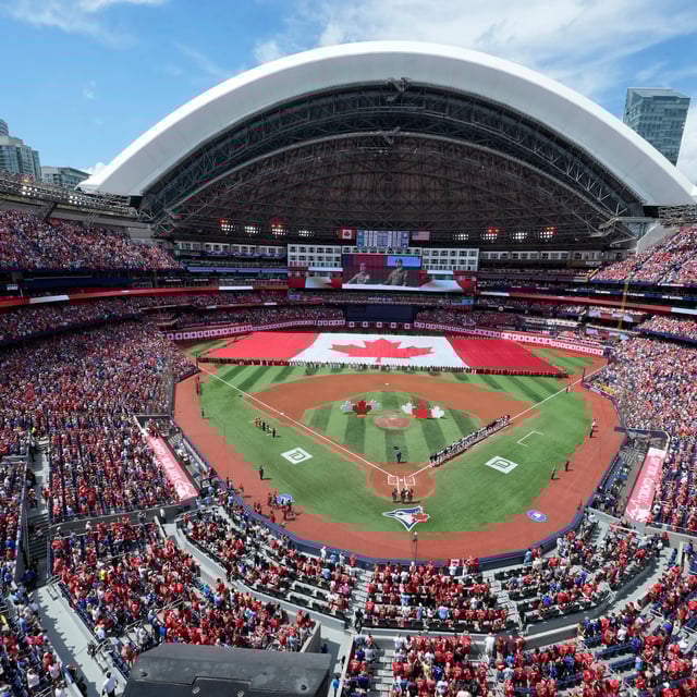 A large Canadian flag is unfurled before the start of the MLB game between the New York Yankees and the Toronto Blue Jays at Rogers Centre on Canada Day, Tuesday, July 1, 2025.  THE CANADIAN PRESS/Frank Gunn
