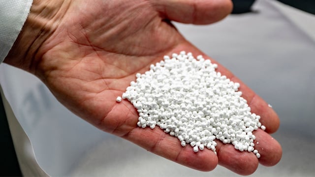 This photograph taken on October 14, 2024, shows a handful of recycled plastic granules sourced from Thailand being used in the manufacturing of carpets at a Condor Carpets factory in Hasselt, northeastern Netherlands. Founded in 2019, Tide collects around 1,000 tonnes of plastic a year from Thailand and other locations. The collected plastic is processed into pellets before being shipped to customers like Condor Group, one of Europe's largest carpet manufacturers. (Photo by Nick Gammon / AFP) / To go with 'PLASTIC-ENVIRONMENT-UN-OCEANS,FOCUS' by Sara HUSSEIN (Photo by NICK GAMMON/AFP via Getty Images)