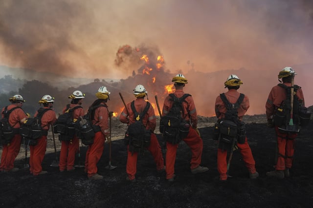 A California Department of Corrections and Rehabilitation fire crew watches as the Canyon Fire burns on Thursday, Aug. 7, 2025, in Hasley Canyon, Calif.
