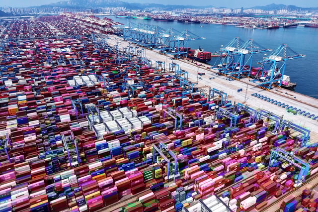 Grúas cargan y descargan contenedores de buques en una terminal de contenedores en Qingdao, en la provincia de Shandong, China, el lunes 11 de agosto de 2025. (Chinatopix vía AP)