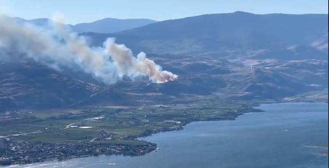 Smoke rises from a new wildfire burning on the west side of Osoyoos Lake on Monday, Aug. 11, 2025.