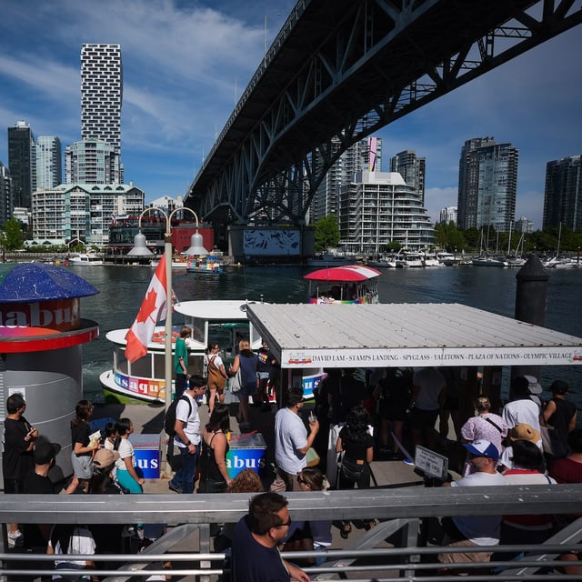 Tourists line up to take an Aquabus water taxi tour of False Creek, from Granville Island in Vancouver, B.C., Friday, Aug. 1, 2025. THE CANADIAN PRESS/Darryl Dyck