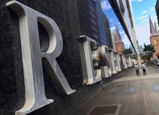 A pedestrian is reflected in a wall of the Reserve Bank of Australia (RBA) head office in central Sydney, Australia, October 3, 2016. Picture taken October 3, 2016. REUTERS/David Gray/File Photo