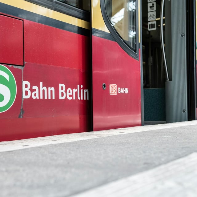 Eine S-Bahn steht mit geöffneten Türen an einem Bahnsteig.