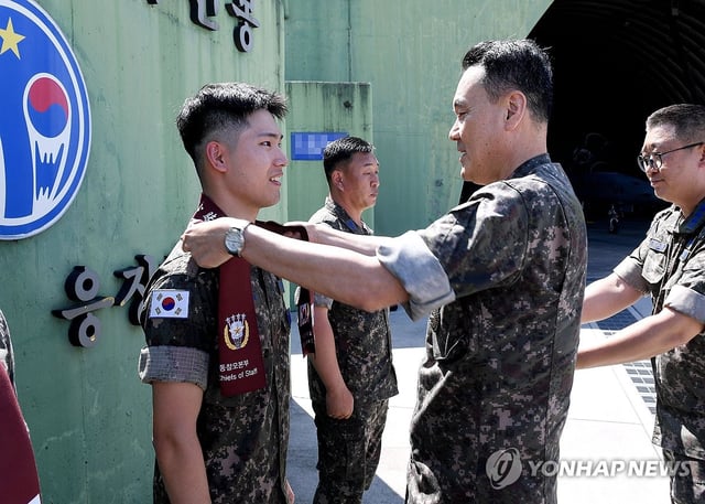 Adm. Kim Myung-soo (R), chairman of the Joint Chiefs of Staff, encourages troops during a visit to the 10th Fighter Wing on Aug. 12, 2025, in this photo provided by his office. (PHOTO NOT FOR SALE) (Yonhap)