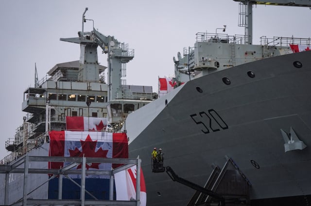 Workers are seen on a lift beside the new Royal Canadian Navy Joint Support vessel before a launch and naming ceremony at Seaspan Shipyards, in North Vancouver, B.C., on Friday, December 13, 2024. The ship is scheduled to be delivered to the Royal Canadian Navy in 2025. THE CANADIAN PRESS/Darryl Dyck