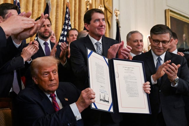 U.S. President Donald Trump holds the signed "Genius Act", which will develop regulatory framework for stablecoin cryptocurrencies and expand oversight of the industry, at the White House in Washington, D.C., U.S., July 18, 2025. REUTERS/Annabelle Gordon/File Photo