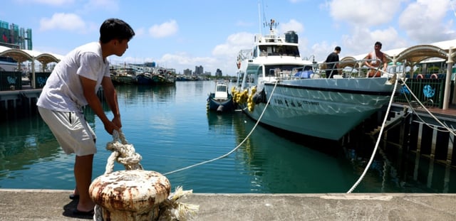Des pêcheurs sécurisent leurs bateaux au port de Wushih à Taïwan à l'approche du typhon Podul le 12 août 2025.