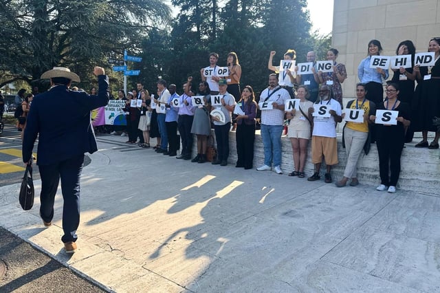 El jefe de la delegación de Panamá en las conversaciones para un tratado contra la contaminación por plásticos, Juan Carlos Monterrey Gómez (izquierda), anima a activistas ambientalistas e indígenas frente al edificio de Naciones Unidas en Ginebra, Suiza, el 12 de agosto de 2025. (AP Foto/Jennifer McDermott)