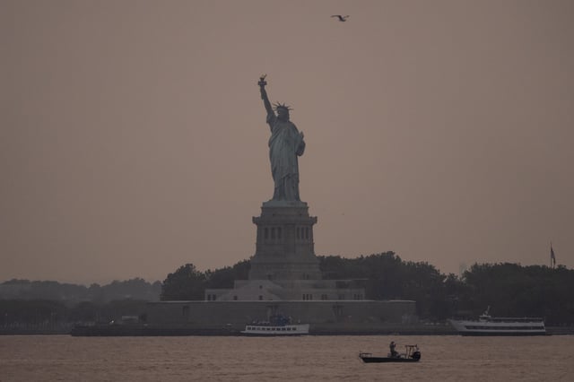 The Statue of Liberty is seen through haze due to Canadian wildfire smoke during sunset, Tuesday, Aug. 5, 2025, in New York.