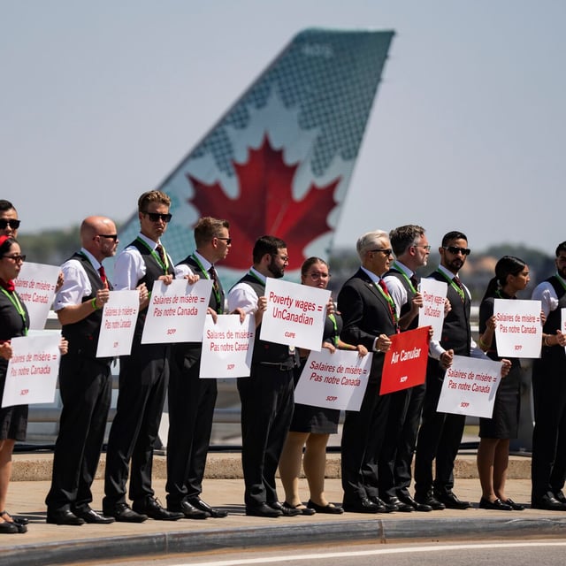 Air Canada flight attendants hold a silent protest at Montreal-Pierre Elliott Trudeau International Airport in Montreal on Monday, Aug. 11, 2025. THE CANADIAN PRESS/Christinne Muschi