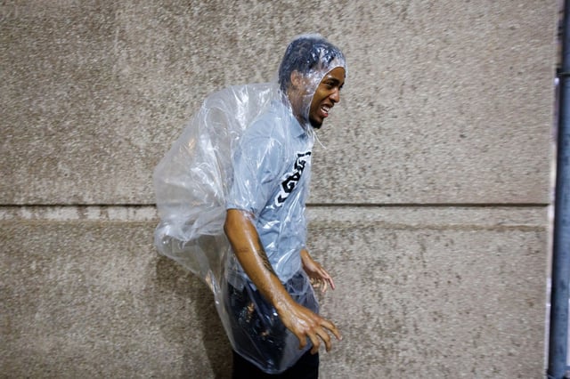 A worker walks in the rain outside Rate Field as a storm system passes through the area, Aug. 11, 2025. (Armando L. Sanchez/Chicago Tribune)
