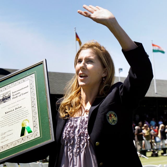 FILE - International Tennis Hall of Fame inductee Monica Seles waves to the crowd as she holds her plaque during ceremonies in Newport, R.I., July 11, 2009. (AP Photo/Elise Amendola, file)
