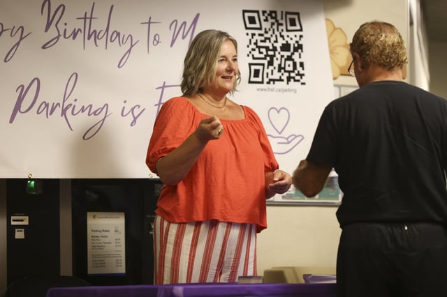 Cancer survivor Krystyna Locke celebrates her birthday by handing out parking passes in the A1 entrance of the Verspeeten Family Cancer Centre at London Health Sciences Foundation in London, Ont., on Tuesday, Aug. 12, 2025. THE CANADIAN PRESS/Nicole Osborne
