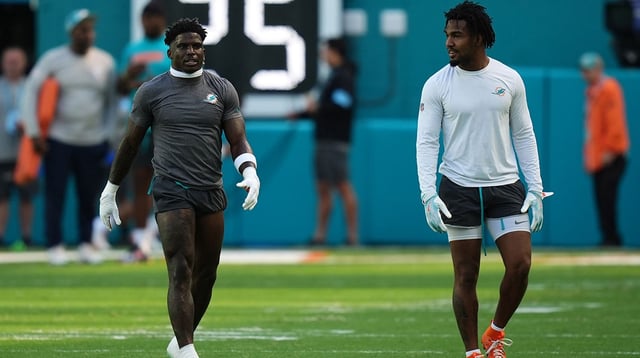 Nov 24, 2024; Miami Gardens, Florida, USA; Miami Dolphins wide receiver Tyreek Hill (L) and Miami Dolphins wide receiver Jaylen Waddle (R) walk on the field prior to the game against the New England Patriots at Hard Rock Stadium. Mandatory Credit: Jasen Vinlove-Imagn Images