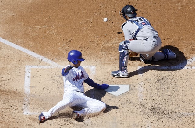 NEW YORK, NEW YORK - JULY 04: Juan Soto #22 of the New York Mets scores a run during the third inning ahead of the throw to J.C. Escarra #25 of the New York Yankees at Citi Field on July 04, 2025 in New York City.