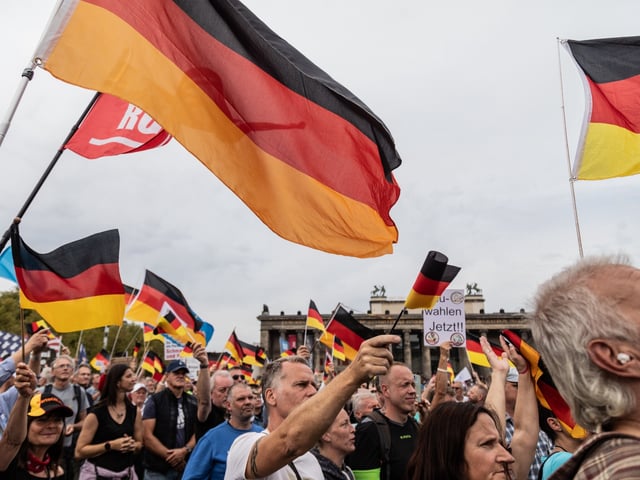 BERLIN, GERMANY - 2023/10/03: Supporters of the far right party AfD (Alternative for Germany) gather and hold German and AfD party flags in front of the Berlin Cathedral on the 33rd anniversary of German Unity Day. Protesters gathered for pro-Russia protest, where they marched from Brandenburg Gate to the Berlin Cathedral during the commemoration of the German Unity Day. The fall of the Berlin Wall on the 9th of November in 1989, which marked the end of the Cold War, paved the way for German reunification barely a year later. The Unification Treaty, which was signed on the 20th of September in 1990 and declared the 3rd of October a national holiday, sealed the end of the division of Germany. (Photo by Nicholas Muller/SOPA Images/LightRocket via Getty Images)