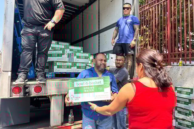 People, who were affected by a water main break that that led to reduced service to nearly 200,000 homes and businesses, pick up cases of bottled water at John F. Kennedy High School in Paterson, N.J., on Aug. 11, 2025. (AP Photo/Ted Shaffrey)