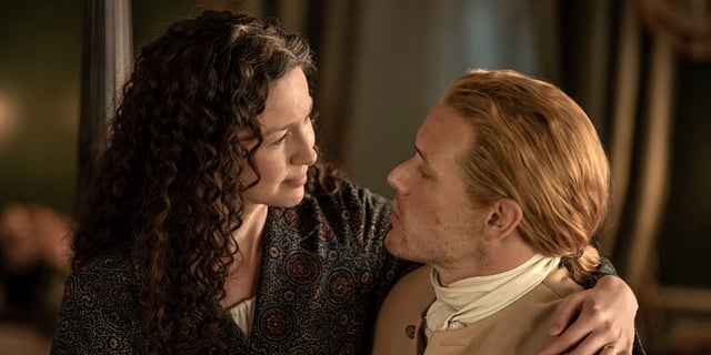 Caitriona Balfe as Claire sitting on the lap of Sam Heughan as Jamie in Season 7 Pt 2 of Outlander