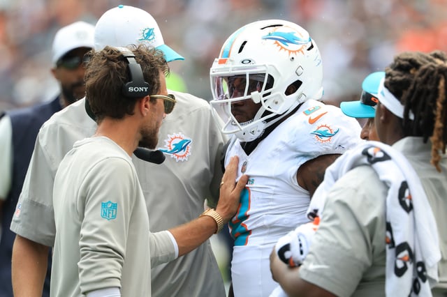 CHICAGO, ILLINOIS - AUGUST 10: Head coach Mike McDaniel of the Miami Dolphins speaks Alexander Mattison #8 after he walks off the field with an injury against the Chicago Bears against the Chicago Bears during the NFL Preseason 2025 game at Soldier Field on August 10, 2025 in Chicago, Illinois.