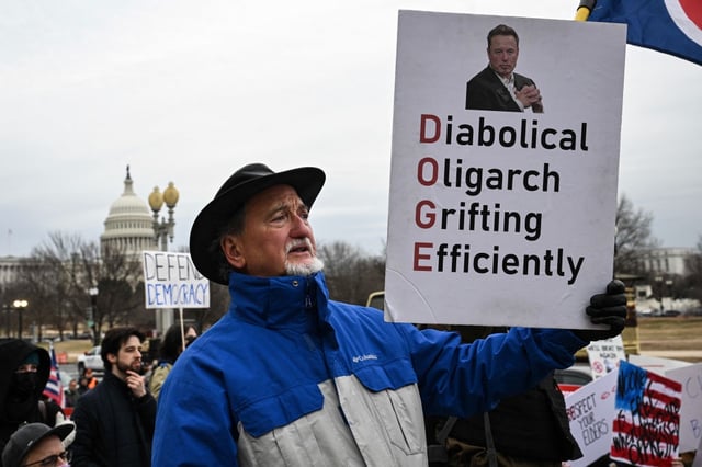 People protest against President Donald Trump and Elon Musk's Department of Government Efficiency (DOGE) outside of the Department of Labor near the U.S. Capitol in Washington, D.C. on Feb. 5, 2025. (Photo by DREW ANGERER/AFP via Getty Images)