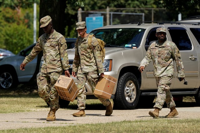 U.S. military personnel walk with boxes of Meals Ready-to-Eat, MREs, outside the D.C. Armory after U.S. President Donald Trump's announcement to deploy the National Guard and federalize the Metropolitan Police Department in Washington, D.C., U.S., August 12, 2025. REUTERS/Elizabeth Frantz