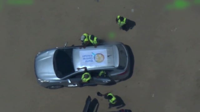 A still from a video released by the IDF shows men wearing yellow vests and standing around a vehicle with a WCK logo on top.