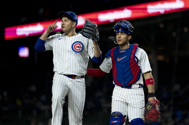 CHICAGO, IL - APRIL 2: Javier Assad and Miguel Amaya of the Chicago Cubs exit the field of play in a game against the Colorado Rockies at Wrigley Field on April 2, 2024 in Chicago, Illinois.
