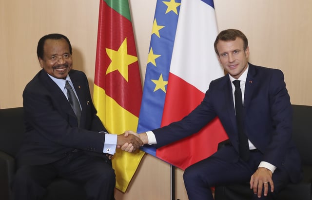 FILE - Cameroon President Paul Biya, left, and France's President Emmanuel Macron shake hands prior to bilateral talks at the Lyon's congress hall, central France, Oct. 10, 2019. (AP Photo/Laurent Cipriani, File)