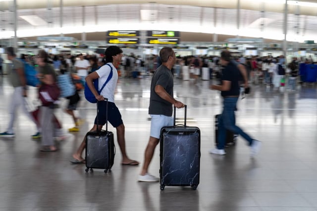 Turistas y viajeros en la zona de salidas de la terminal T1 del aeropuerto de Barcelona-El Prat, que se encamina a cerrar otro año de récord en volumen de tráfico aéreo