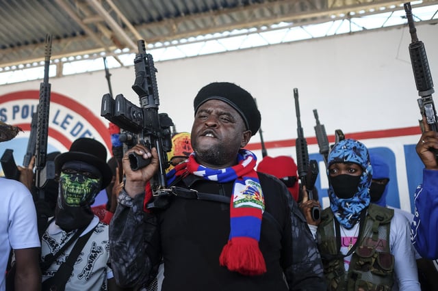 FILE - Leader of the "G9 and Family" gang, Jimmy Cherizier, better known as Barbecue, shouts slogans with his gang members after giving a speech, as he leads a march against kidnappings, through the La Saline neighborhood in Port-au-Prince, Haiti, Oct. 22, 2021. (AP Photo/Matias Delacroix, File)