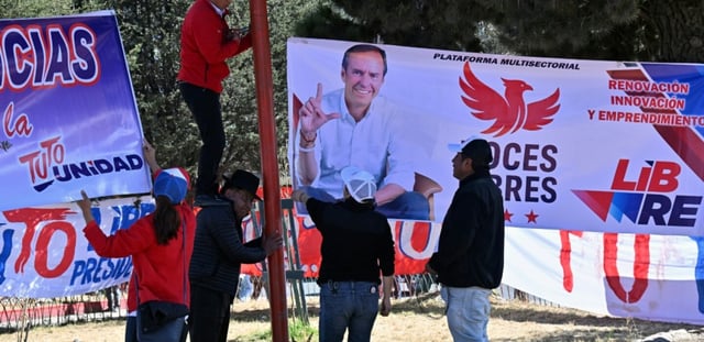 Les partisans de l'ancien président bolivien et candidat à la présidence pour la coalition "Alianza Libre" (Alliance libre), Jorge "Tuto" Quiroga, accrochent une banderole lors de son dernier meeting électoral à Villa Adela, à El Alto, dans le département de La Paz, en Bolivie, le 9 août 2025