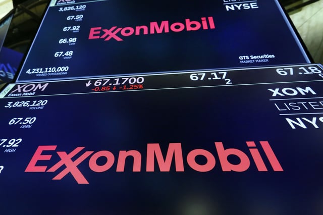 FILE - The ExxonMobil logo appears above a trading post on the floor of the New York Stock Exchange, Oct. 8, 2019. (AP Photo/Richard Drew, File)