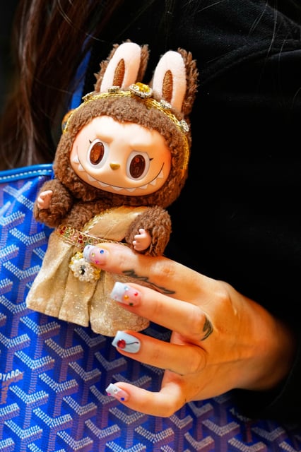 FILE - Diep Nguyen shows a Labubu doll to media during the opening of Germany's first shop for Labubu plush dolls in Berlin, July 25, 2025. (AP Photo/Markus Schreiber, File)