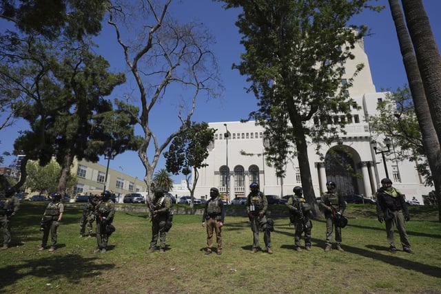 FILE - Federal agents stage at MacArthur Park, July 7, 2025, in Los Angeles. (AP Photo/Damian Dovarganes, File)