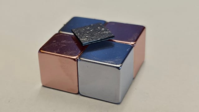 The graphite composite plate wiggles above the magnets for a long time but loses energy over time due to air friction