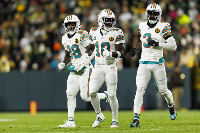 GREEN BAY, WISCONSIN - NOVEMBER 28: Running back De&#39;Von Achane #28 of the Miami Dolphins, wide receiver Tyreek Hill #10, and wide receiver Odell Beckham Jr. #3 get set during an NFL game against the Green Bay Packers at Lambeau Field on November 28, 2024 in Green Bay, Wisconsin.