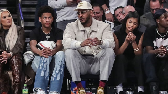 Oct 25, 2023; New York, New York, USA; Former NBA player Carmelo Anthony (r) sits with his son Kiyan Anthony (l) at the game between the Boston Celtics and the New York Knicks at Madison Square Garden. Mandatory Credit: Wendell Cruz-Imagn Images