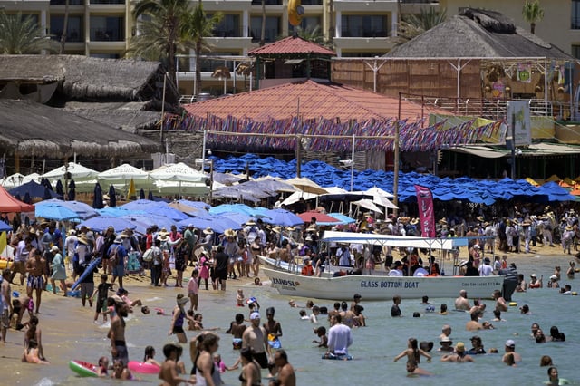 Tourists can be seen enjoying the beach at a resort in Los Cabos, Baja California, Mexico on July 15, 2025. (Photo by Alfredo ESTRELLA / AFP) (Photo by ALFREDO ESTRELLA/AFP via Getty Images)