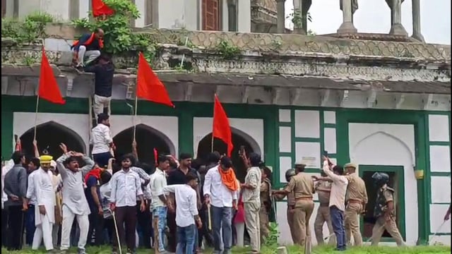 Supporters of Hindu organisations gather near an old tomb, claiming it is a temple and demanding to offer prayers, at Abu Nagar, in Fatehpur on Monday. (ANI Video Grab)