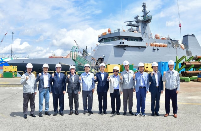Foreign Minister Cho Hyun (C), acting U.S. Ambassador to South Korea Joseph Yun (7th from L) and other officials pose for a photo while touring HD Hyundai Heavy Industries Co.'s shipyard in Ulsan, about 300 kilometers southeast of Seoul, on Aug. 13, 2025, in this photo provided by the South Korean shipbuilder. (PHOTO NOT FOR SALE) (Yonhap)