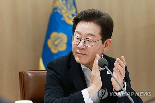 President Lee Jae Myung claps as he attends a meeting at the presidential office in central Seoul on Aug. 13, 2025. (Pool photo) (Yonhap)