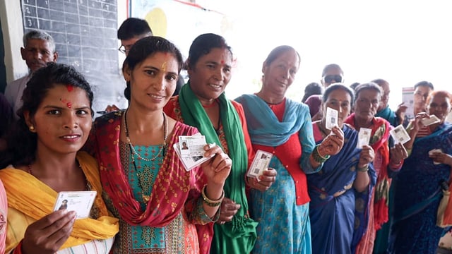 Women voters stand in queue
