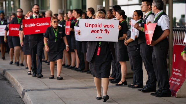 Air Canada flight attendants during a demonstration at Toronto Pearson International Airport in Mississauga, Ontario, Canada, on Monday, Aug. 11, 2025. Workers represented by the Canadian Union of Public Employees (CUPE), are holding a simultaneous action at airports in Montreal, Toronto, Vancouver, and Calgary, to raise awareness about ongoing issues related to their working conditions. Photographer: Arlyn McAdorey/Bloomberg