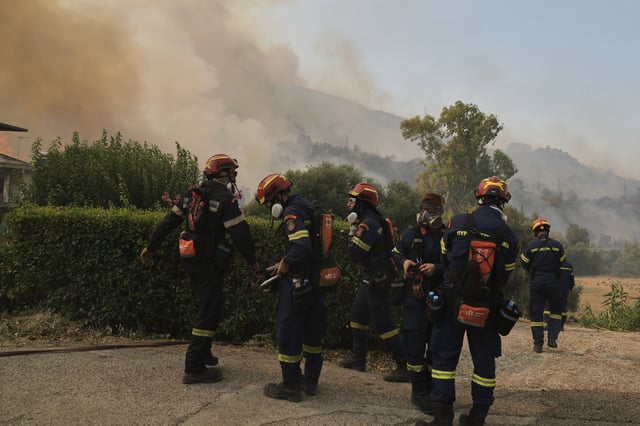 Firefighters prepare to control the wildfire in Vounteni, on the outskirts of Patras, western Greece, Wednesday, Aug, 13, 2025. (AP Photo/Thanassis Stavrakis)