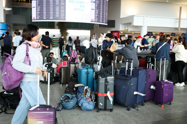 People wait with their luggage at a terminal at JFK International Airport in New York on June 16, 2025.