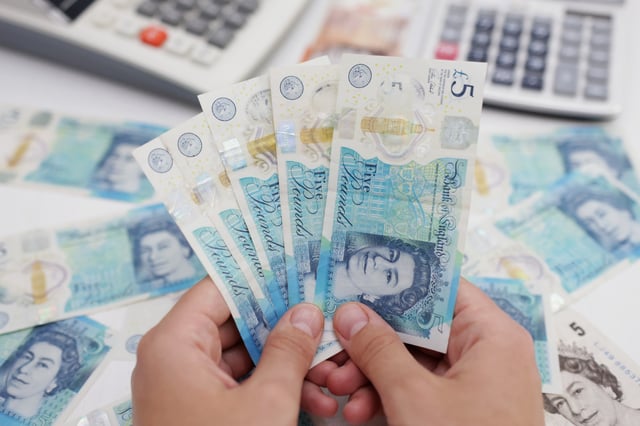 Woman holds British Pound banknotes in this illustration taken May 30, 2022. REUTERS/Dado Ruvic/Illustration/File Photo