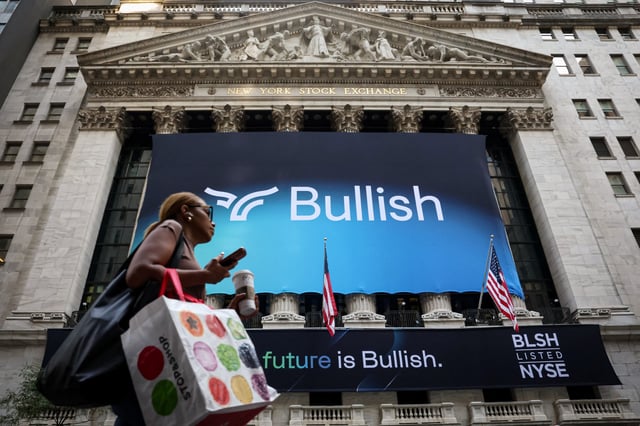 A person walks past a banner for Bullish, a cryptocurrency exchange operator, during the company's IPO at the New York Stock Exchange (NYSE) in New York City, U.S., August 13, 2025.  REUTERS/Brendan McDermid