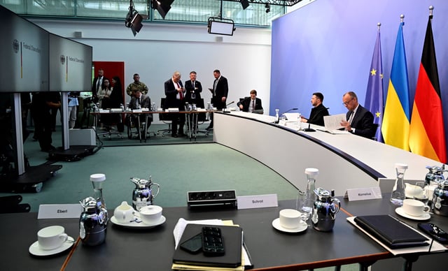Ukrainian President Volodymyr Zelenskiy and German Chancellor Friedrich Merz (R) wait for the beginning of a virtual talk between European leaders with the US President on the Ukraine war ahead of the summit between the US and Russian leaders, in Berlin, Germany, on August 13, 2025. European leaders will hold online talks with US President Donald Trump, hoping to convince him to respect Ukraine's interests when he discusses the war with Putin in Alaska on Friday.     JOHN MACDOUGALL/Pool via REUTERS